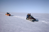 An Inuit family travelling to a Spring camp by snowmobile. Igloolik, Nunavut, Canada. 1992