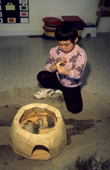 An Inuit child playing with a model igloo at playschool in Igloolik, Nunavut, Canada. 1999
