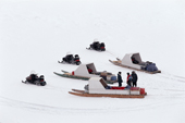 Snowscooters pulling sleds with 'family boxes' gather on the sea ice. Bylot Island Nunavut. Canadian Arctic. 1999