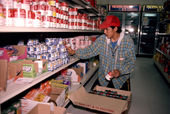 An Inuit youth stacking shelves at the store in Grise Fiord, Ellesmere Is. Nunavut, Canada. 1994