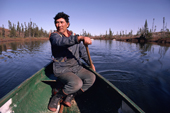 Cree Trapper, Abel Brien paddles his canoe while out hunting in the autumn. Quebec, Canada. 1988