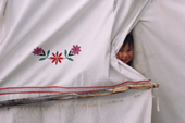 A Cree boy, Johnnie, peeps through the tent door at a camp out on the land. Quebec, Canada. 1988