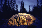 The light from a kerosene lamp illuminates a Cree winter tent in boreal forest. Quebec, Canada. 1988