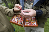 Max and Bryan select a fly from a fly box. They are fishing for Salmon on the River Findhorn. Scotland
