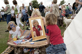 Children gravitate to the face painter at the Sturminster Newton Cheese Festival. Dorset. England
