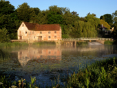 Sturminster Newton watermill in late May with mist rising off the water. Dorset. England