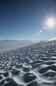 Wind-sculpted snow on the  polar plateau.Fenriskjeften Mountains in background. Queen Maud Land. Antarctica.