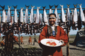 Chukchi girl in her dancing costume by fish drying racks. Maynapylgino, Chukotka. Siberia, Russia.