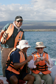 Tour guide Panga driver and a visitor with a digital camera near Isabela. Galapagos Island