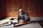 Craftsman carving a wooden panel for a houseboat wall. Kashmir, India. 1986