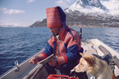 Sami reindeer herder Aslak Logje enjoys some fishing watched by his dog. North Norway. 1985