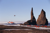 Helicopter lands tourists from an icebreaker by the rocks at Cape Tegetthoff. Hall Is. Franz Josef Land. 1998