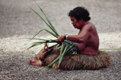 An elderly woman weaves a basket from palm leaves, on Ngulu Atoll. Yap, Micronesia. 1996