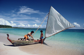 Two boys prepare to sail in outrigger canoe, to fish in Woleai lagoon. Yap, Micronesia, Pacific. 1996