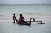 Islander from Faraulep Atoll with pet Booby bird prepares to fish in small outrigger canoe. Yap, Micronesia. 1996
