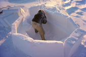 Fur clad Inuk, Qaaviganguaq, builds an igloo. It will be used as a hunting shelter. N.W. Greenland. 1980