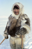 Fur clad Inuit hunter, Qaavigannguaq, standing by his sled. He wears a caribou skin jacket & polar bear pants. NW Greenland. 1980