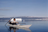 Nukagpianguaq out hunting in a kayak uses a throwing board to hurl his harpoon. Qeqetat, Thule, Northwest Greenland. (1980)