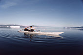 Nukagpianguaq out hunting in a kayak uses a throwing board to hurl his harpoon. Qeqetat, Thule, Northwest Greenland. (1980)