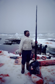 Inuit hunter, Jakob Petersen, stands proudly holding a seven foot long Narwhal tusk. Northwest Greenland. Northwest Greenland. 1980