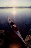 Inuit Kayak with avatak (sealskin float) by the shore in the summer midnight sun. N.W. Greenland. 1980
