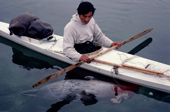 Nukagpianguaq, an Inuit hunter, returns to shore in his kayak with a ringed seal he has caught in Inglefield Bay. Northwest Greenland. 1980