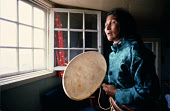 Sofie Eipe, an Inuit woman, drum sings using a traditional drum. Only the rim of the drum is struck. Qaanaaq, Avanersuaq, Northwest Greenland. (1980)