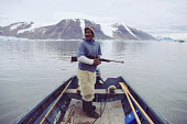 Ituko, an Inuit hunter, out seal hunting in a boat in Granville fiord. Northwest Greenland. (1985)