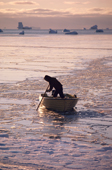 Inuit hunter works to get his boat through the pancake ice at freeze-up. Moriussaq. North West Greenland. 1987