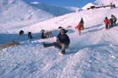 Inuit children tobogganing down a snowy slope in Siorapaluk. North West Greenland. Northwest Greenland. 1977