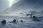 Storm in the Inuit village of Siorapaluk, blows snow around the sleds and houses. Thule, Northwest Greenland. (1977)