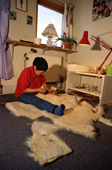 Mikivssuk Karlsen, an Inuit woman, making a pair of traditional polar bear skin trousers. N.W.Greenland. 1998