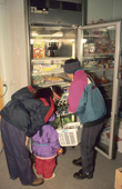 Inuit shoppers taking food products from a refrigerated cabinet in the store at Savissivik. Northwest Greenland. 1998