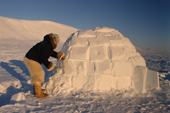 Kajutaq Avike, an Inuit hunter puts the finishing touches to an Igloo. Northwest Greenland. 1998