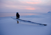 Qaerngak Nielsen, an Inuit hunter, drags his kayak to the ice edge near Cape York. N.W.Greenland. 1998