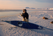 At minus 32 degrees Celsius, Qaerngak Nielsen, an Inuit hunter scrapes ice off his kayak. N.W.Greenland. 1998