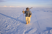 Qaerngak Nielsen, an Inuit hunter, walks on newly formed sea ice near Cape York. Northwest Greenland. 1998