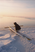 Qaerngak Nielsen, An Inuit hunter, gets into his kayak at the ice edge near Cape York. N.W.Greenland. 1998