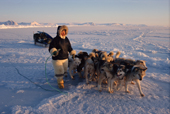 Qaergak Nielsen, an Inuit hunter walks infront of his dog team while out seal hunting. N.W. Greenland. 1998