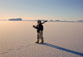 Qaerngak Nielsen, an Inuit hunter, walks on thin newly formed sea ice near Cape York. Northwest Greenland. (1998)