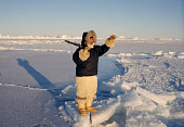 Qaerngak Nielsen, an Inuit hunter, points out a route across the sea ice near Cape York. Northwest Greenland. (1998)