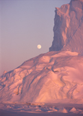 The moon rising behind a large iceberg in Inglefield Bay in low winter light. N.W. Greenland. 1998