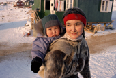 Inuit woman carrying a baby in an Amaut (hooded sealskin jacket).Thule, N.W.Greenland. 1998