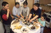 Inuit family eating traditional foods at a Birthday party in Qaanaaq. N.W.Greenland. 1998