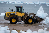 A front loader being used to collect glacial ice for the community's water supply in Qaanaaq. Northwest Greenland. 2008