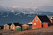 Houses in the Inuit community of Qaanaaq. Behind them is Inglefield Bay, with its water full of icebergs and bergy bits. Avanersuaq, Northwest Greenland.