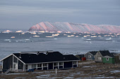 View from Qaanaaq of icebergs in Inglefield Bay in front of Herbert Island at sunrise in the autumn. Qaanaaq, Northwest Greenland.(2021)