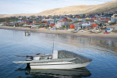 An Inuit hunter's boat with a kayak on board in the harbour at Qaanaaq during the summer. Northwest Greenland. (2022)