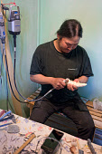 Putdlak Odak, an Inuit artist from Qaanaaq, working on a Tupilaq he is carving from a walrus tusk. Qaanaaq, Northwest Greenland (2022)