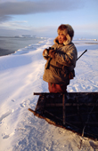 Standing by his baidarka (walrus skin boat), Yakov Vukutagin, hunts seals from the shoreline at Dezhnovka. Chukotka, Siberia, Russia. 2004